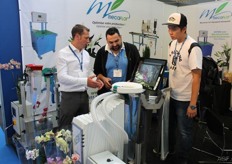 Evan Kakouros (middle) from Australia gets a demonstration of how the new MecaFlor packaging machine works